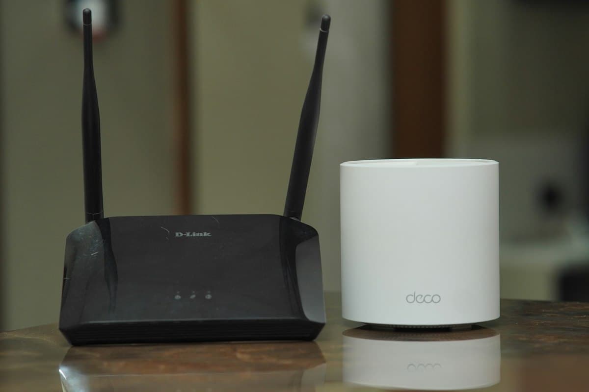 Two home routers side by side on a table, a plain reference for the kind of simple network setup most small rentals actually have